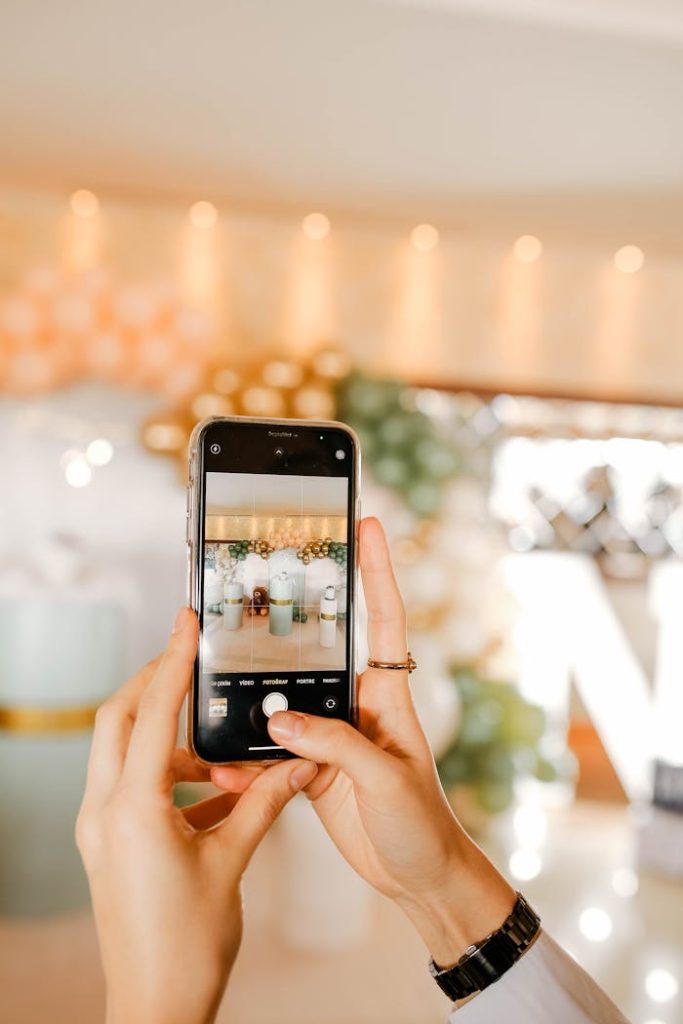A person photographing a festive event using a smartphone.